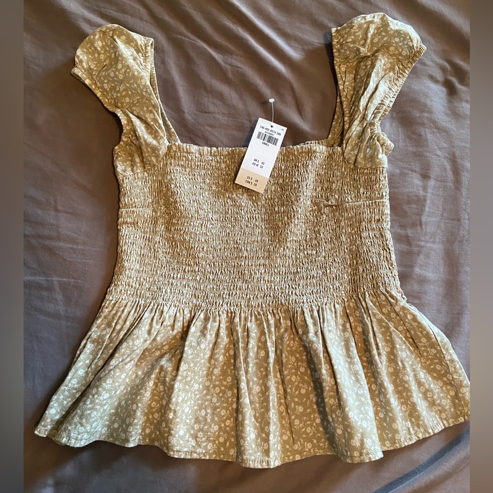 Smocked crop top with capped sleeves. Green floral pattern. Size small. NWT.